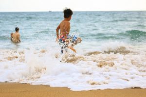 Beach boy splashing in the waves